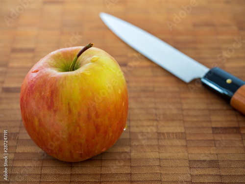 Apfel mit Messer auf Holzbrett