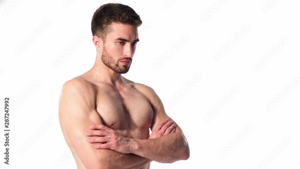A young sports man with a beard, looking in frame and smiling. The naked torso and muscular muscles of men. Handsome guy looking at camera on a white background A young sports man with a beard, looking in frame and smiling. The naked torso and muscular muscles of men. Handsome guy looking at camera on a white background