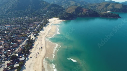 Seaside view of Pauba beach, Sao Sebastiao, Brazil. Blue seaside scene. Urban city near the beach. Blue seaside in a paradisiac beach. Great cityscape and beach scene. photo