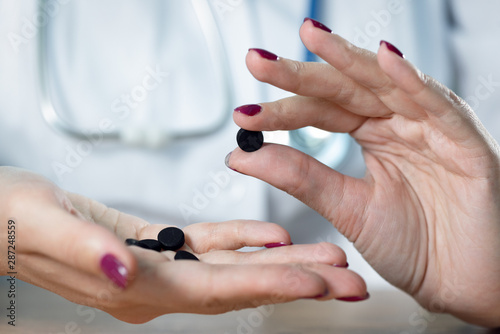 Doctor showing in hands activated charcoal.