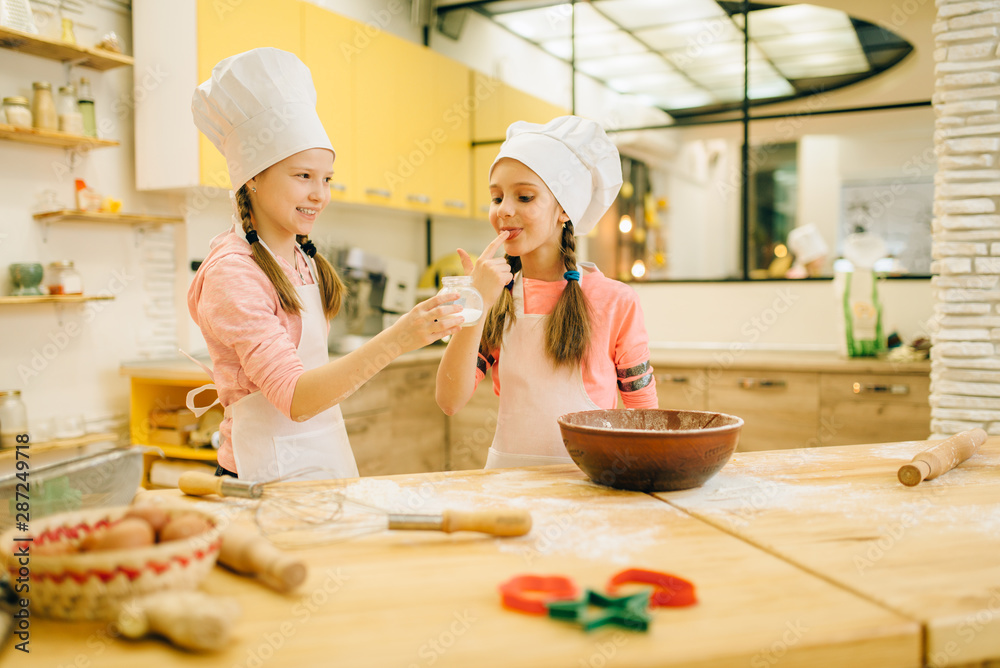 Little girls cooks in caps tastes vanilla powder Little girls cooks in caps tastes vanilla powder