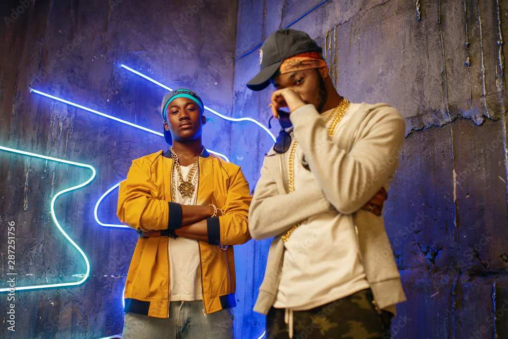 Two black rappers, neon lights on background