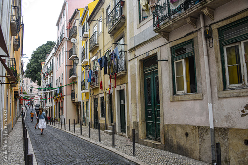 Fototapeta Naklejka Na Ścianę i Meble -  Lisbon, Portugal - July 27, 2019: A typical narrow streets in the Old Town of Alfama, Lisbon