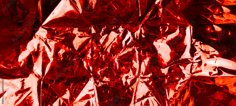 Red shiny wrinkle foil paper as background four your design.