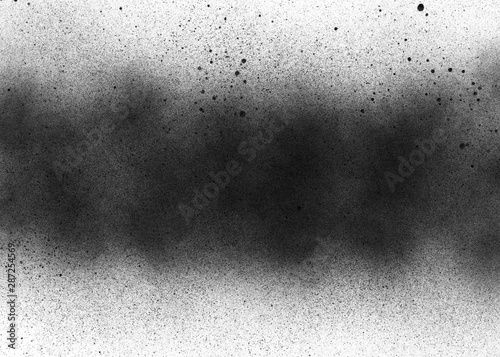 Subtle grit texture of black spray track on white paper. Particles and blots of paint