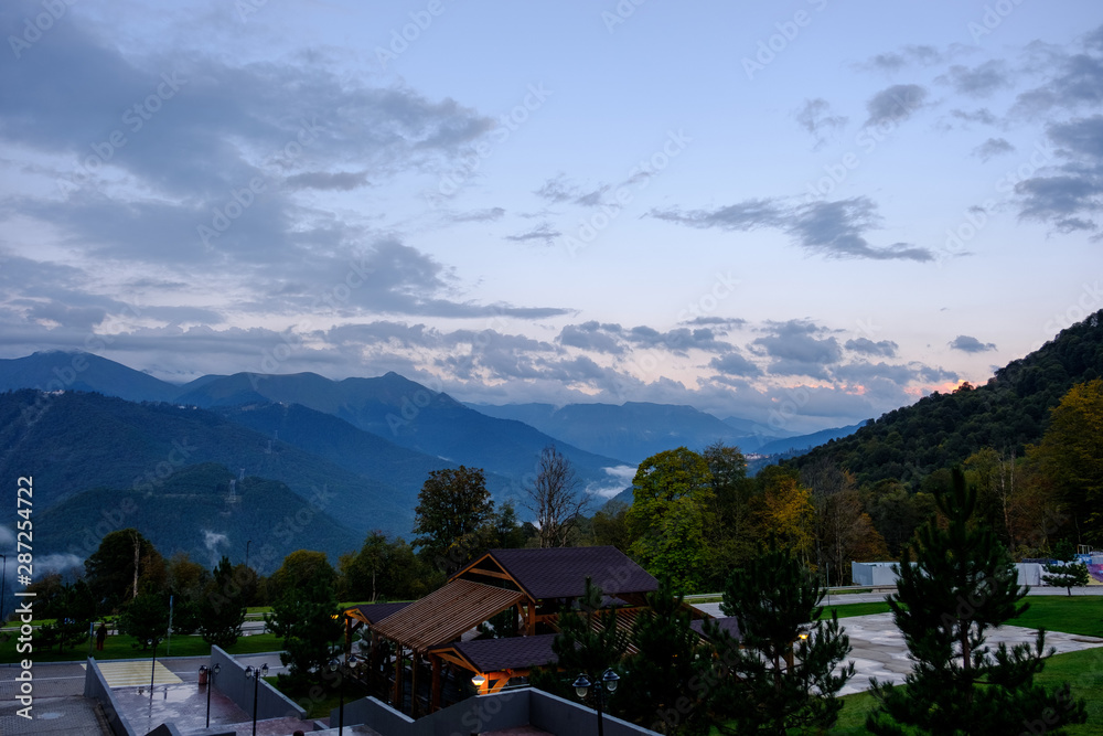 Evening panorama of a mountain resort against a cloudy sky
