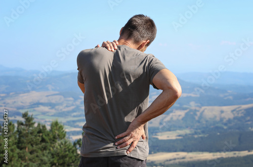 Back pain relief. Man hiker with back pain