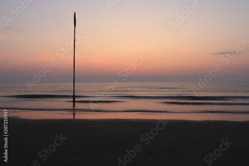 sunset on the sea with a pole