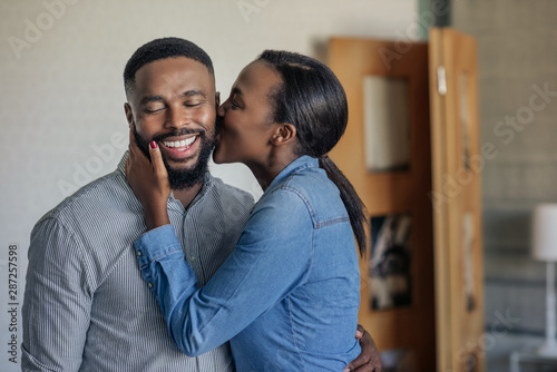Canvas-taulu Loving African American wife kissing her husband on the cheek