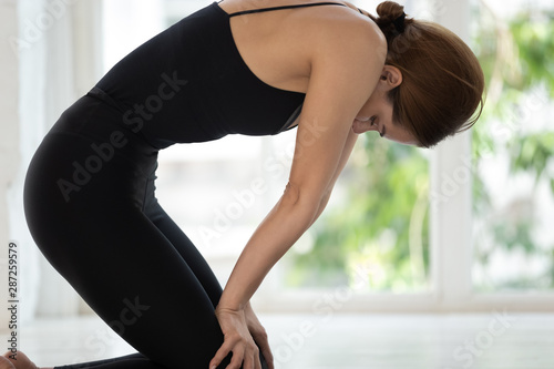 Young woman practicing yoga, doing Uddiyana Bandha exercise