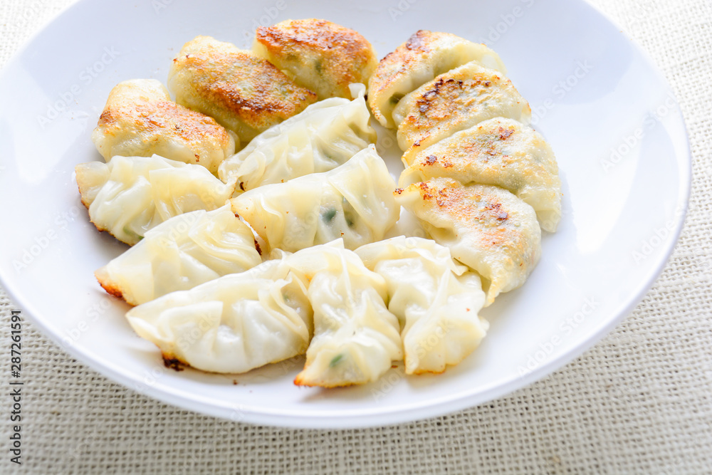 Japanese Fried Dumplings, the half moon-shaped dumplings served in Asian restaurants as an appetiser or side dish, pork and vegetable filling. Japanese Fried Dumplings, the half moon-shaped dumplings served in Asian restaurants as an appetiser or side dish, pork and vegetable filling.
