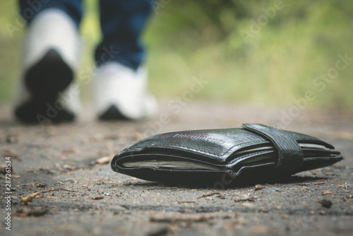 Lost wallet on road and is walking away woman.