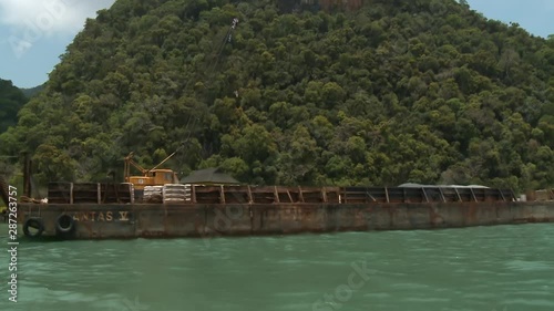 Handheld, medium wide shot of a crane on a docked barge. photo