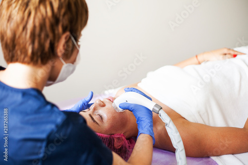 Woman getting LPG hardware massage at the beauty clinic. Professional beautician working.