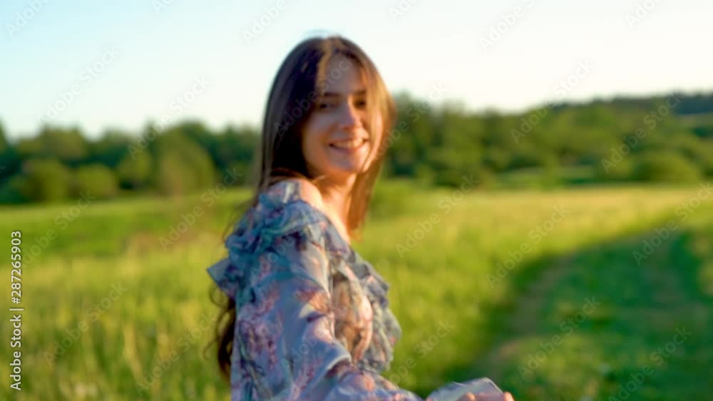 young beautiful girl with long hair walks in a summer field on sunset, girl model. Walk in nature and fresh air young beautiful girl with long hair walks in a summer field on sunset, girl model. Walk in nature and fresh air