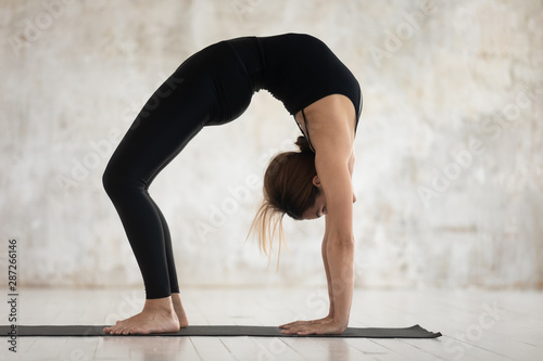 Young woman practicing yoga, Bridge exercise, Urdhva Dhanurasana photo