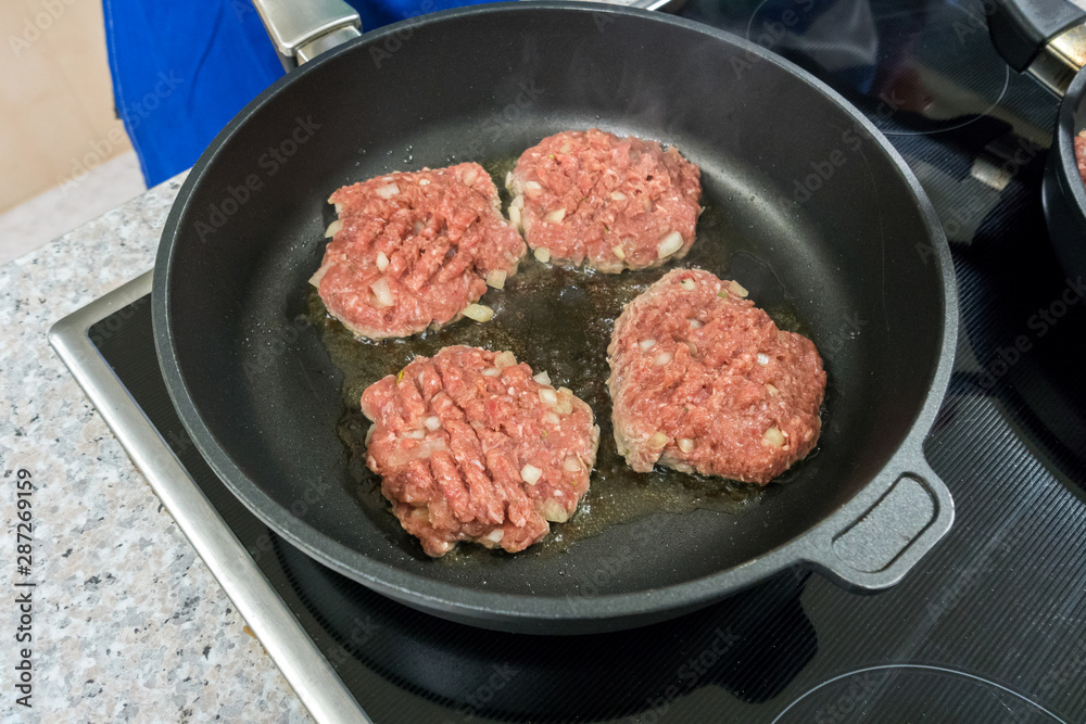 Burger patties are fried in a pan Burger patties are fried in a pan