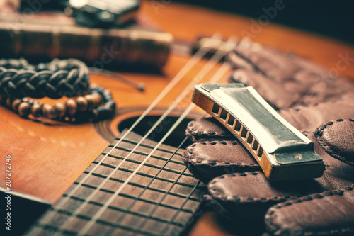 vintage harmonica on acoustic guitar photo