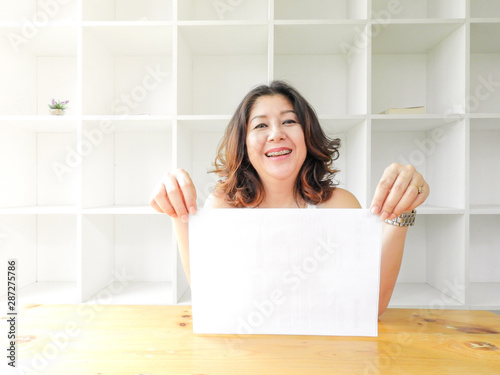 Attractive beautiful woman holding blank white paper.