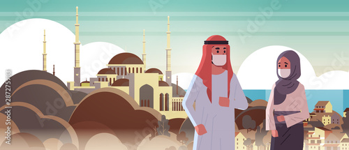 arab couple wearing face masks environmental industrial smog dust toxic air pollution virus protection concept arabic man woman walking outdoor mosque building cityscape portrait horizontal