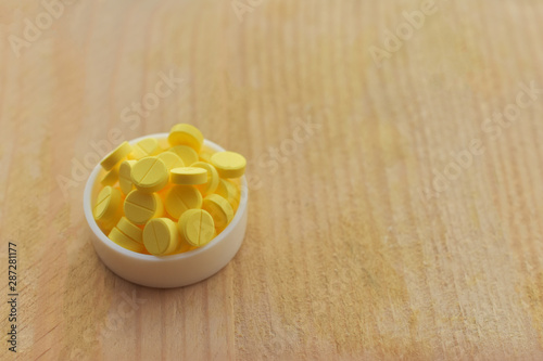 Yellow pills on wood table