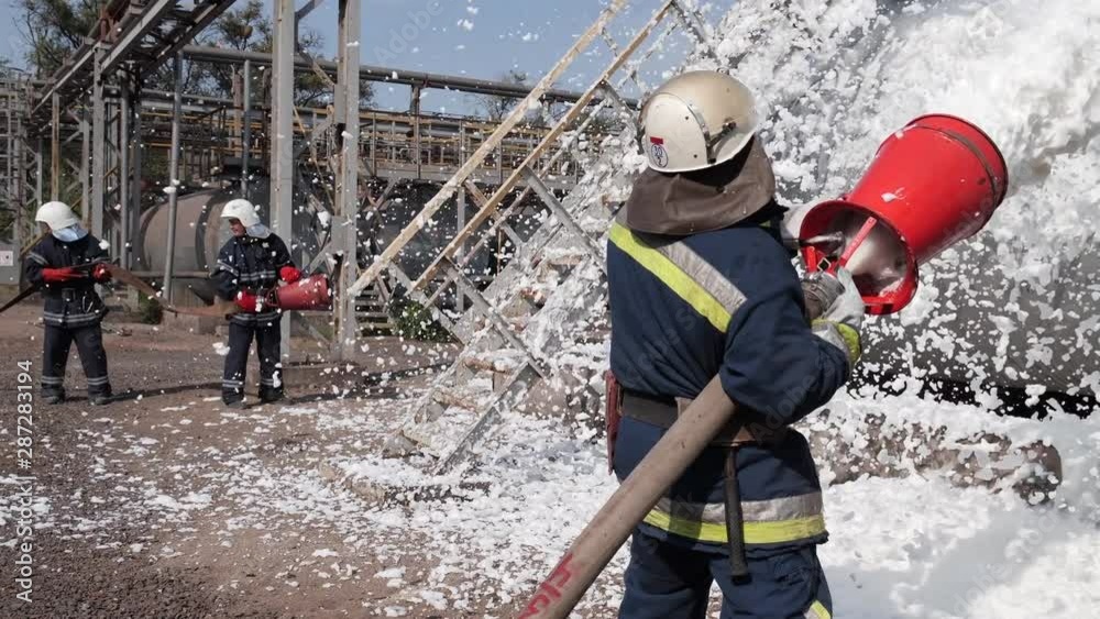 Firefighters extinguish an oil tank with foam
