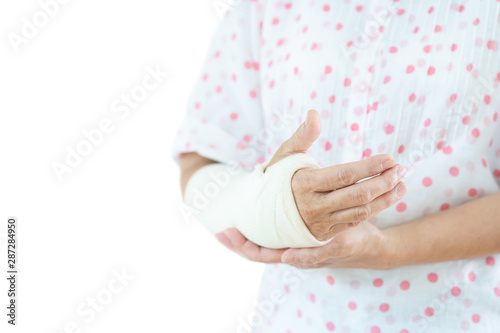 Adult Asian woman broken arm from accident, close up in half body with copy space.  Concept of health care and aging society.  Isolated on white background. © DG PhotoStock