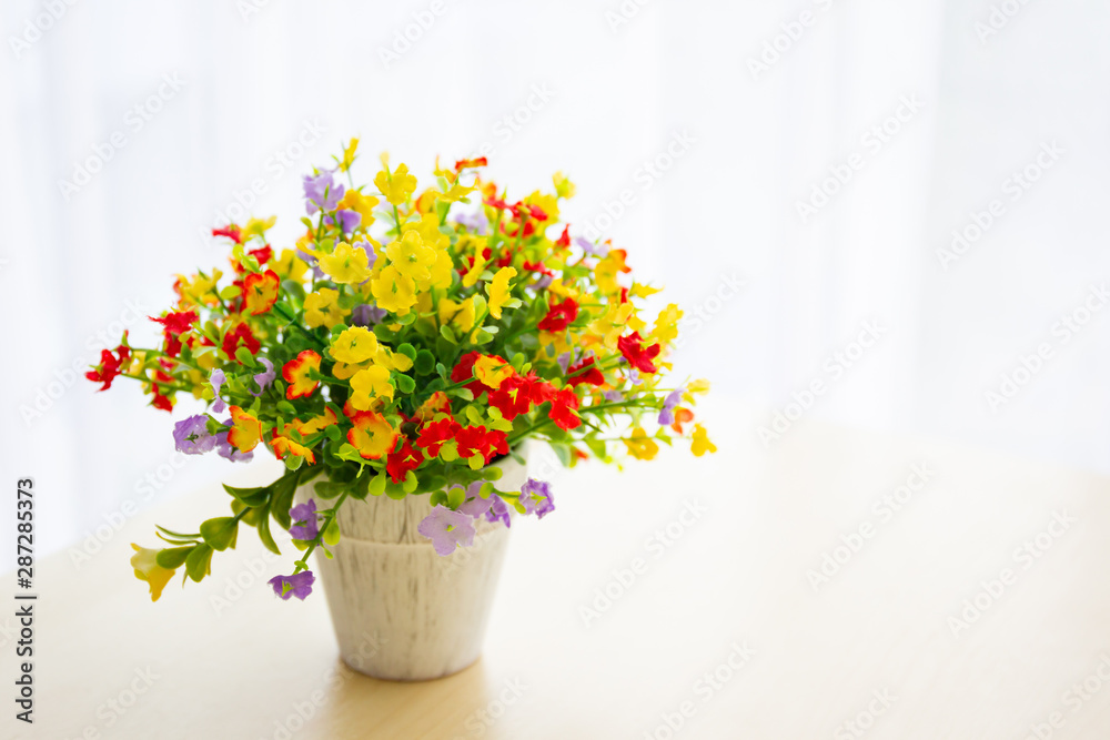 Handcraft bouquet of flowers in vase, flower bouquet on a wooden table beside the window with soft lighting, copy space in photograph.