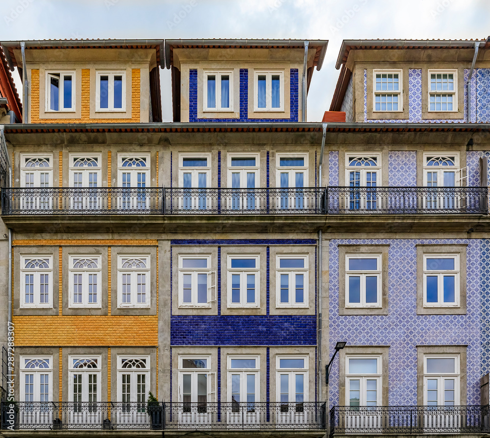 Facades of traditional houses decorated with ornate Portuguese azulejo tiles in Porto, Portugal