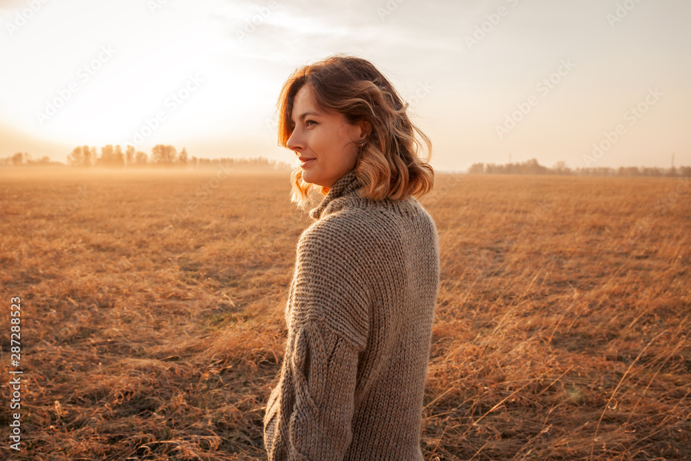 Beauty charming woman in summer in the field. Outdoor close up portrait of young woman is happy and feels free. Autumn walking concept. Beauty charming woman in summer in the field. Outdoor close up portrait of young woman is happy and feels free. Autumn walking concept.