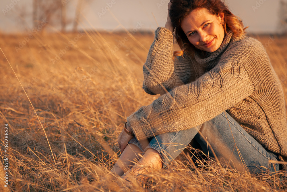 Beauty charming woman in summer in the field. Outdoor close up portrait of young woman is happy and feels free. Autumn walking concept. Beauty charming woman in summer in the field. Outdoor close up portrait of young woman is happy and feels free. Autumn walking concept.