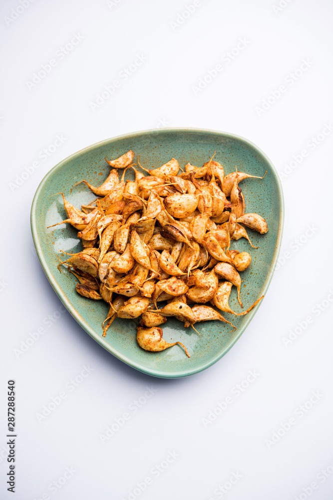 Garlic Fry or Tala Hua Lahsun in hindi, is a popular side dish or snacks from maharashtra, India Garlic Fry or Tala Hua Lahsun in hindi, is a popular side dish or snacks from maharashtra, India