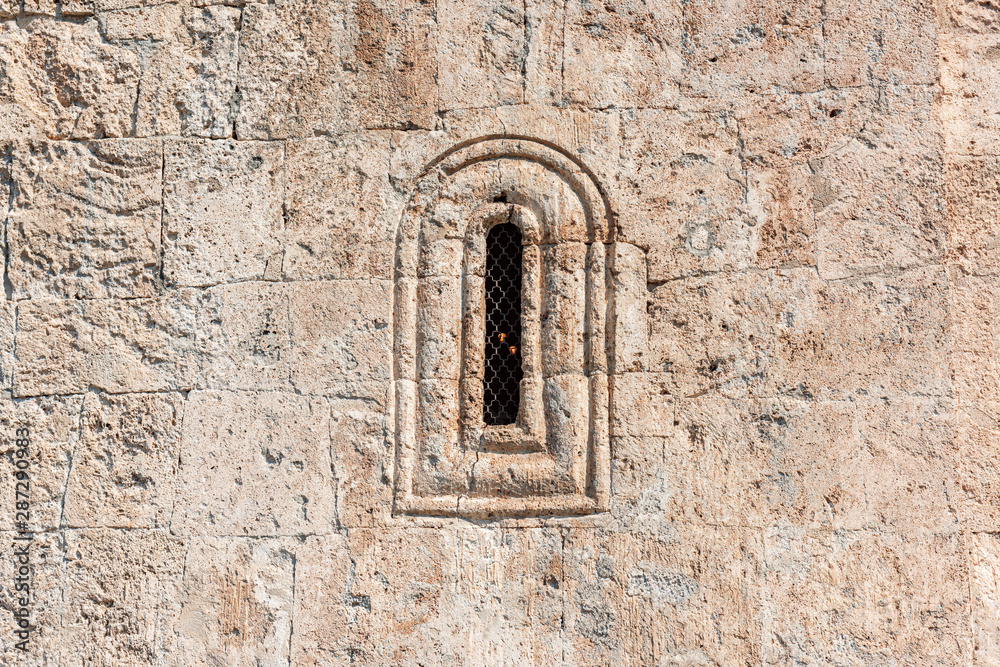 Window in the wall of an ancient Albanian temple in the village of Kish, the city of Sheki