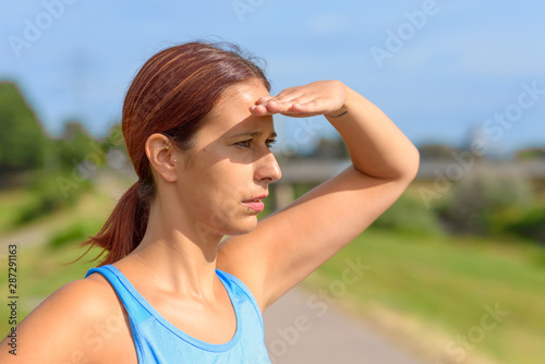 Attractive tanned woman standing watching