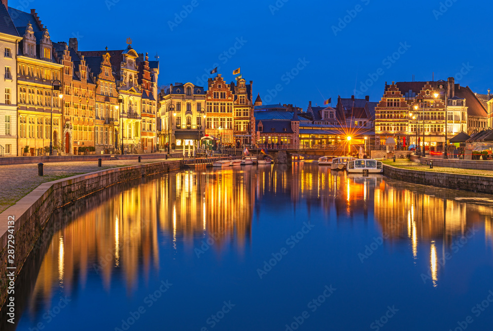 Cityscape of Ghent (Gent) city during the blue hour with its historic flemish guild houses having a reflection in the Leie river, East Flanders, Belgium.