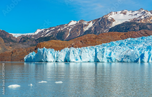 The majestic Grey Glacier in summer with small icebergs in Lago Grey with the Andes mountain range in the background, Torres del Paine national park, Puerto Natales, Patagonia, Chile. photo