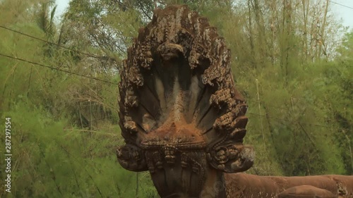 A steady closeup view of a carved stone monument in the entrance of Spean Praptos, a 1000-year old Khmer bridge in Kompong Kdei, Cambodia that is used to be the longest corbeled stone-arch bridge in photo