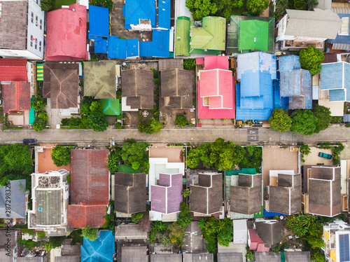 Aerial top-down view high altitude of slum a heavily populated urban informal settlement characterized by substandard housing and squalor poor living conditions streets and rusty metal home roof tops © mkitina4