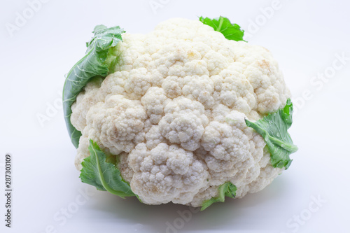 Cauliflower on a white background with leaves and water droplets