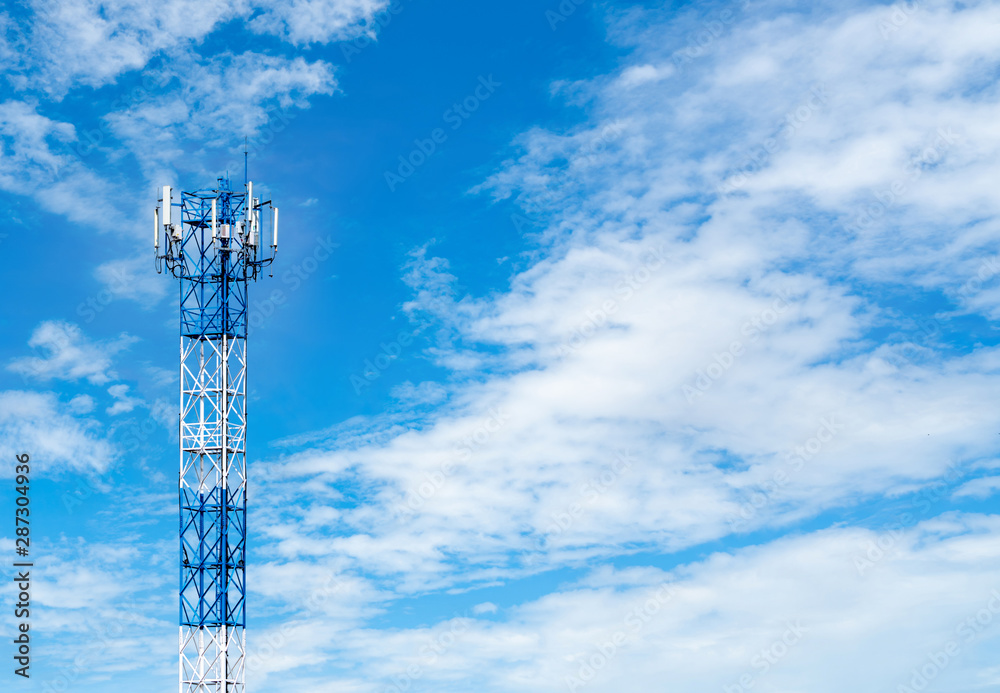 Telecommunication tower with blue sky and white clouds background. Antenna on blue sky. Radio and satellite pole. Communication technology. Telecommunication industry. Mobile or telecom 4g network.