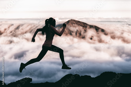 Photo Trail runner athlete silhouette running in mountain summit background clouds and peaks background