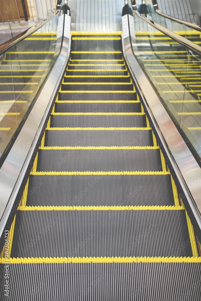 Moving down escalator in the community mall. Moving down escalator in the community mall.
