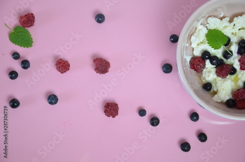 Bild auf Leinwand Ricotta with fresh berries and honey on pink table