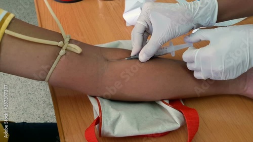 Nurses use a needle to draw blood for medical examinations.