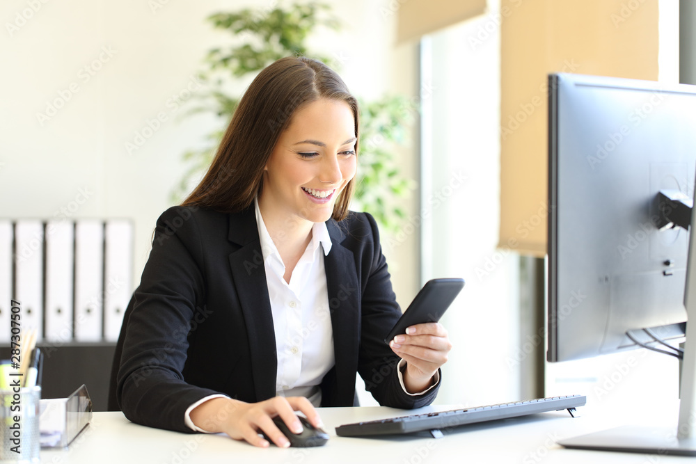 Happy businesswoman checking phone text at office Happy businesswoman checking phone text at office