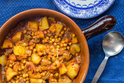 Chick pea, vegetables and meat curry in earthern ware casserole dish photo