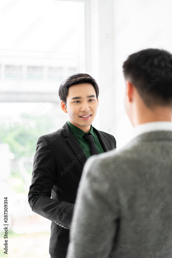 Young asian businessman shakes hands to his partner agrees to cooperate in business. / business concept / cooperate work / successful job. Young asian businessman shakes hands to his partner agrees to cooperate in business. / business concept / cooperate work / successful job.