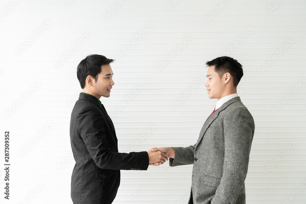 Young asian businessman shakes hands to his partner agrees to cooperate in business. / business concept / cooperate work / successful job. Young asian businessman shakes hands to his partner agrees to cooperate in business. / business concept / cooperate work / successful job.