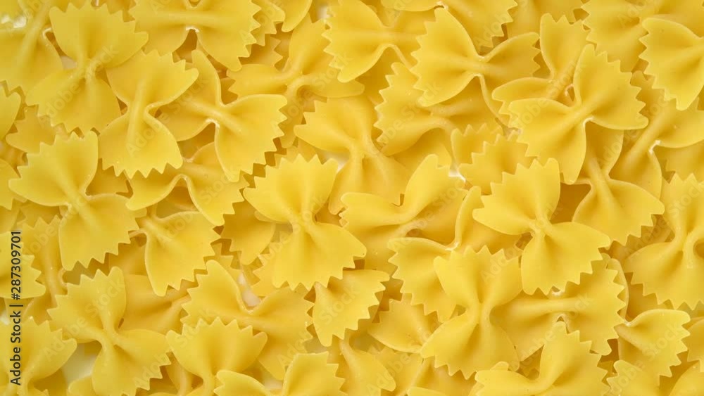 Uncooked farfalle or bow-tie pasta rotating top view Uncooked farfalle or bow-tie pasta rotating top view