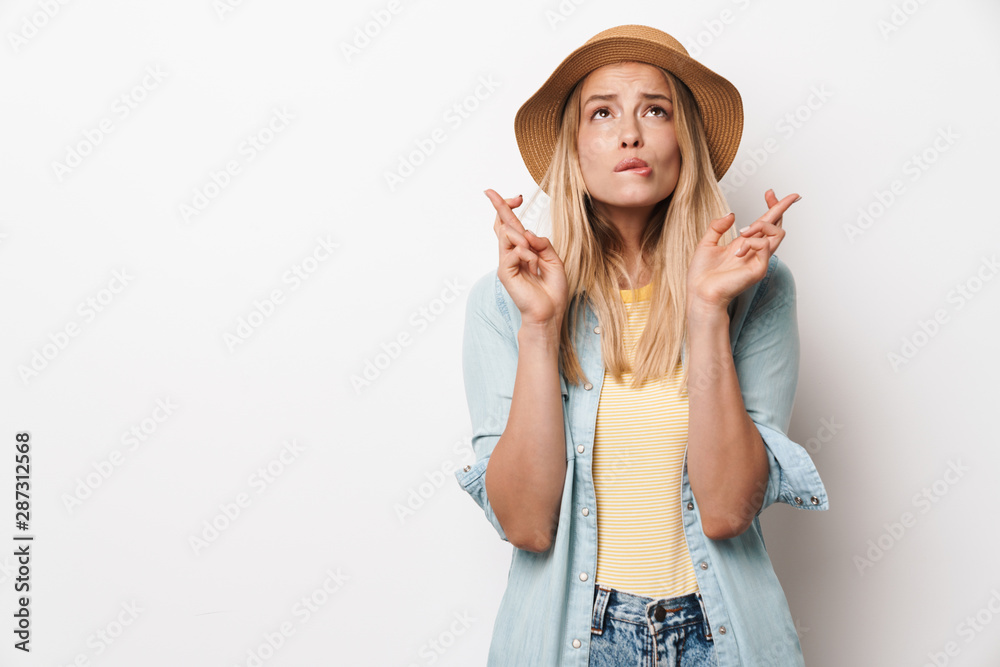 Nervous amazing young pretty woman wearing hat posing isolated over white wall background make hopeful please gesture. Nervous amazing young pretty woman wearing hat posing isolated over white wall background make hopeful please gesture.